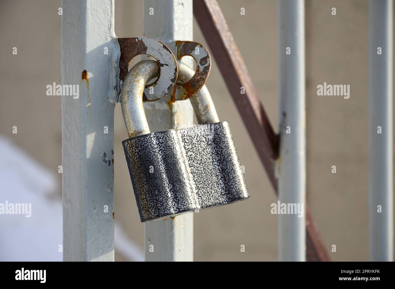 Un grand cadenas gris est suspendu à une porte en métal Banque D'Images