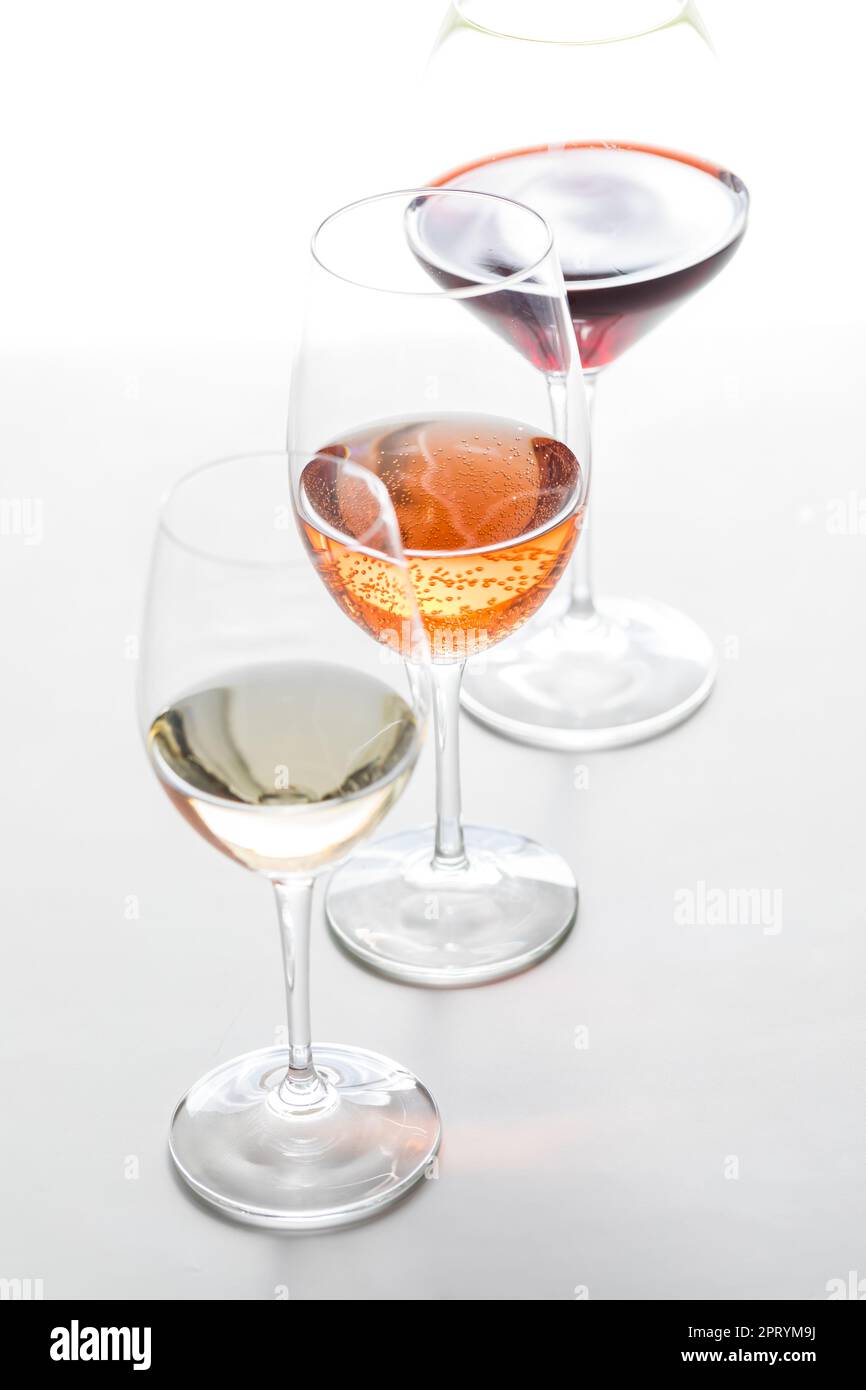 Trois verres de différents vins dans une rangée, sur fond blanc. Banque D'Images