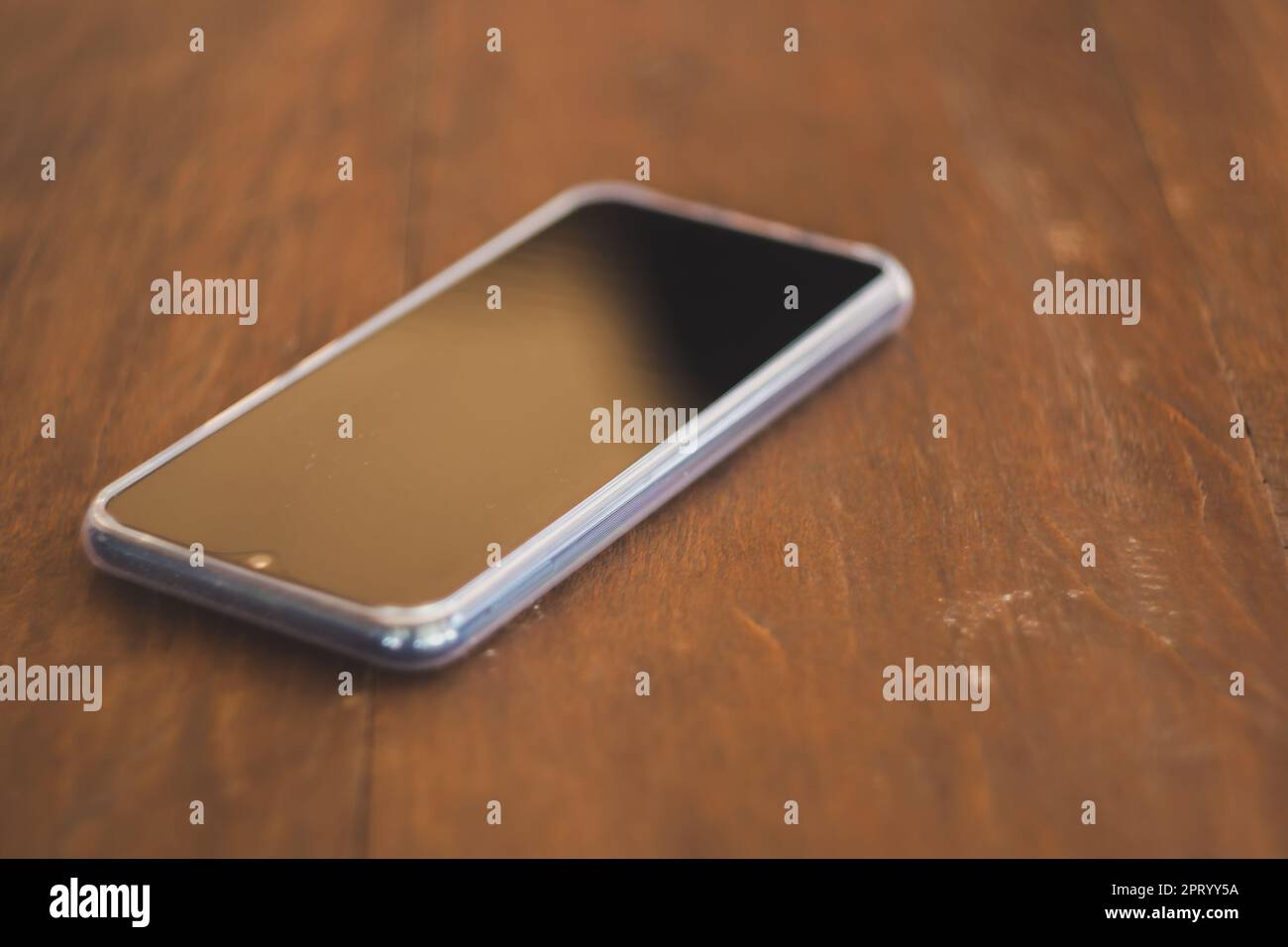 Smartphones noirs placés sur une table en bois marron Banque D'Images