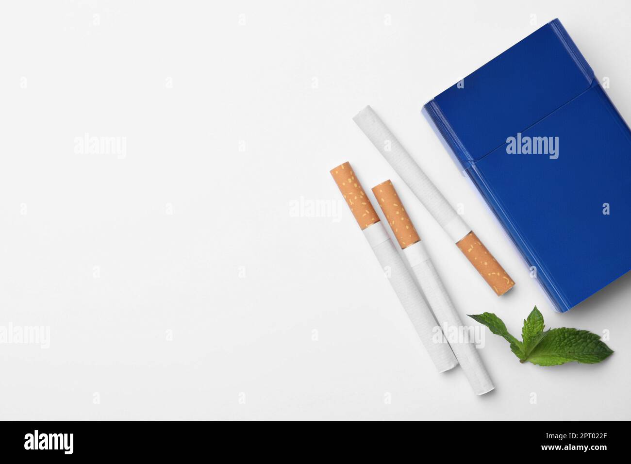 Cigarettes de menthol, paquet et menthe sur fond blanc, plat. Espace pour le texte Banque D'Images