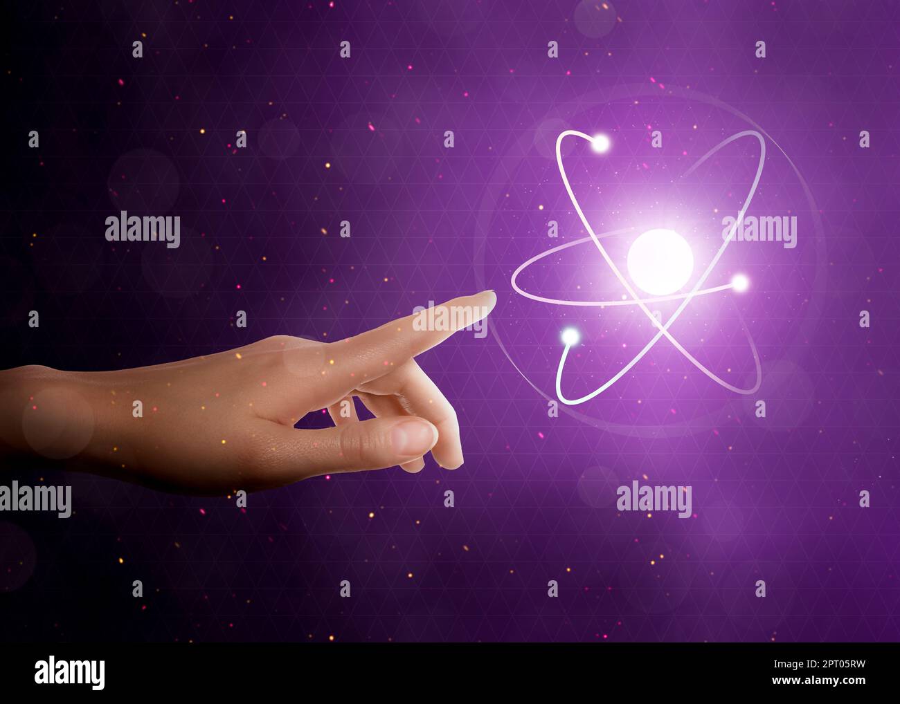 Femme pointant vers le modèle virtuel de l'atome sur fond violet, gros plan Banque D'Images