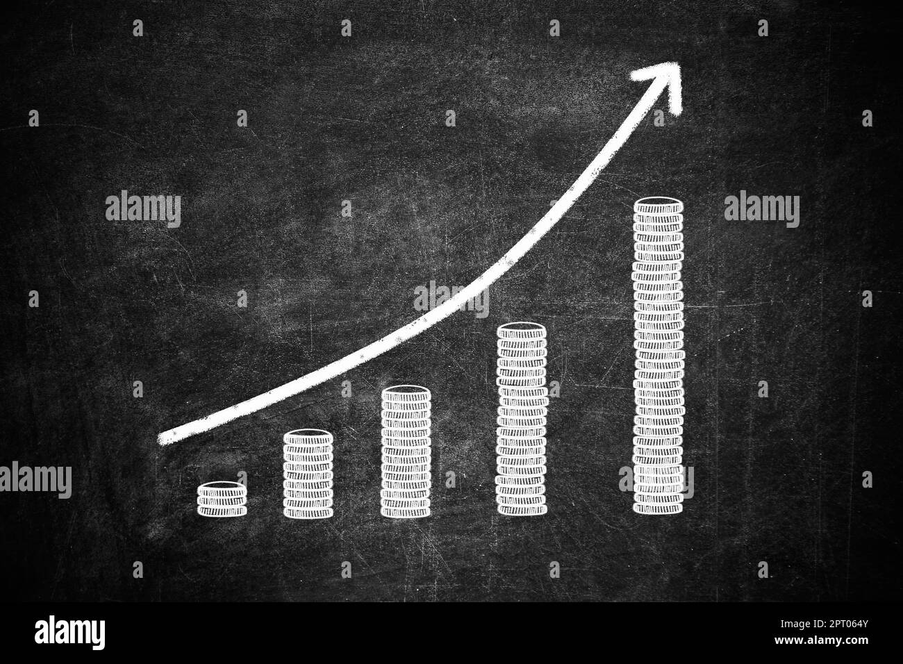 Concept d'augmentation de salaire. Flèche vers le haut et pièces empilées sur tableau noir Banque D'Images