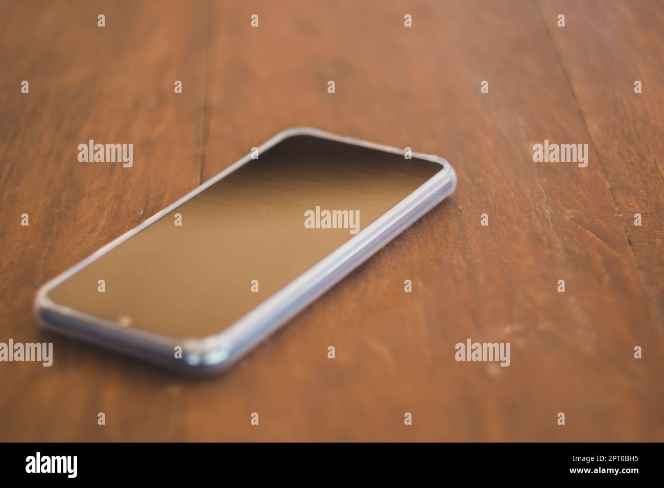 Smartphones noirs placés sur une table en bois marron Banque D'Images