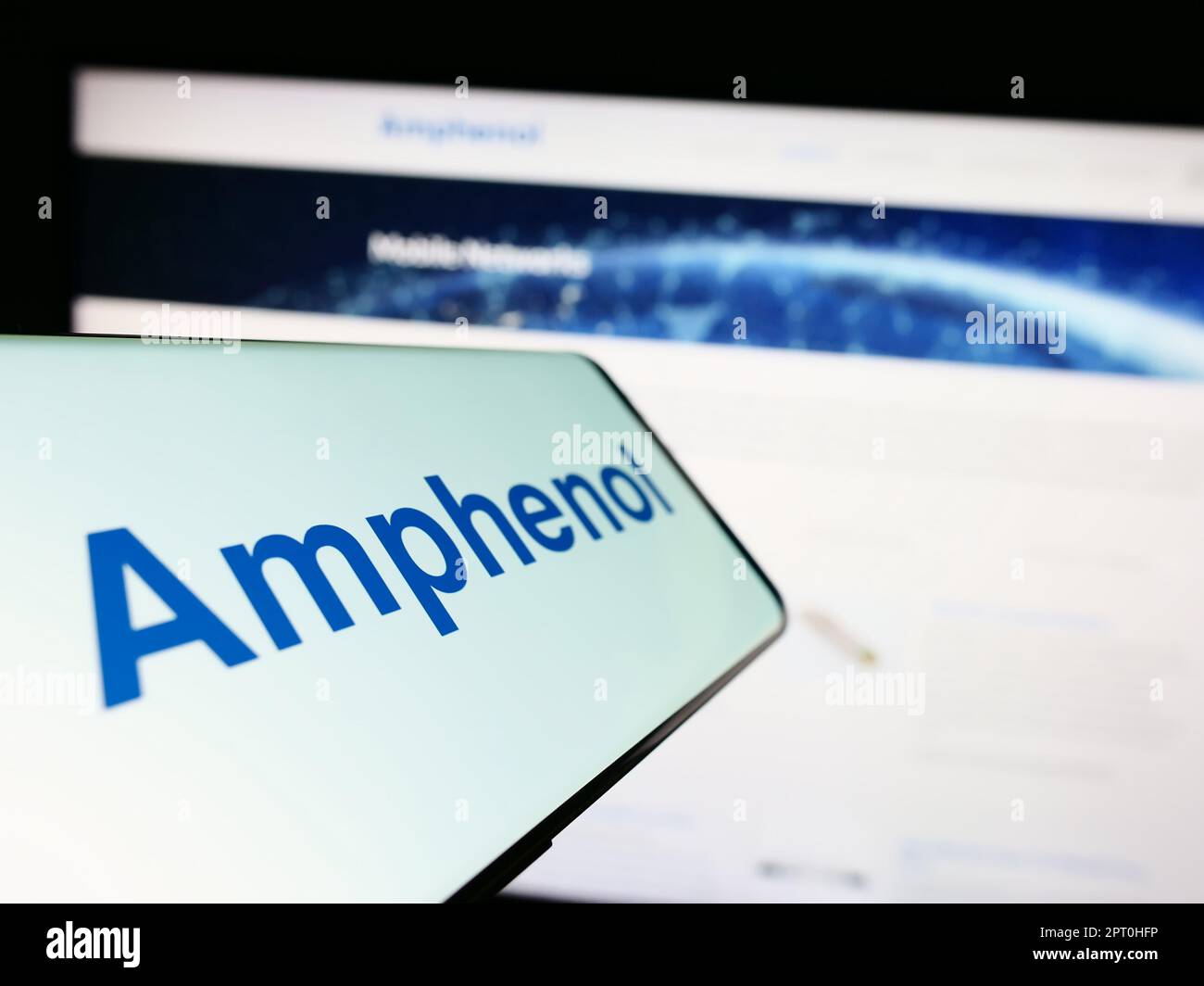 Téléphone portable avec logo de la société américaine d'électronique Amphenol Corporation à l'écran devant le site Web. Concentrez-vous sur le centre de l'écran du téléphone. Banque D'Images