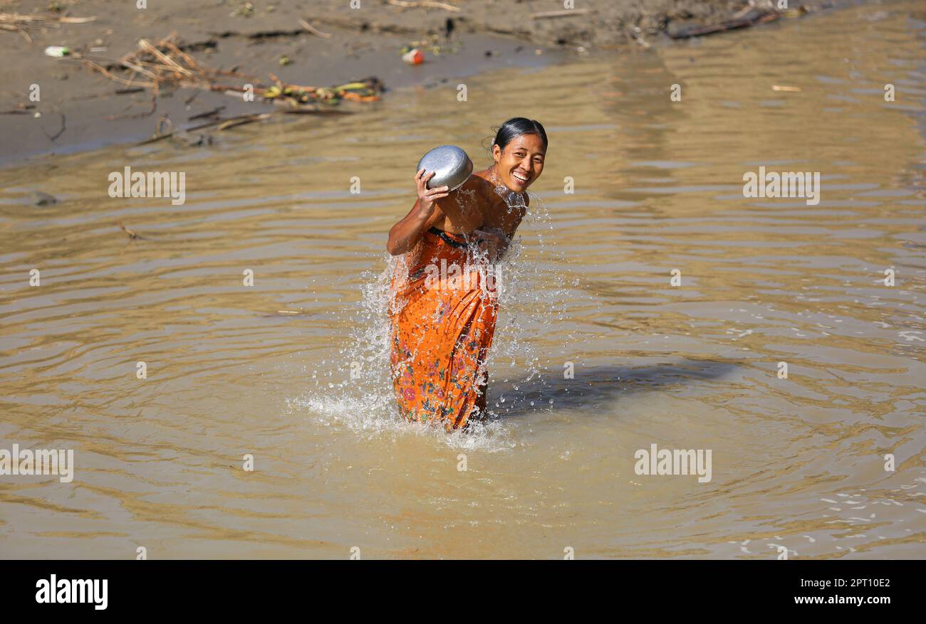 Femme birmane se baignant et se lavant pendant la canicule de l'Asie du Sud-est, la vie le long de la rivière Irrawaddy, records de canicule, plus grande voie navigable au Myanmar (Birmanie) Banque D'Images