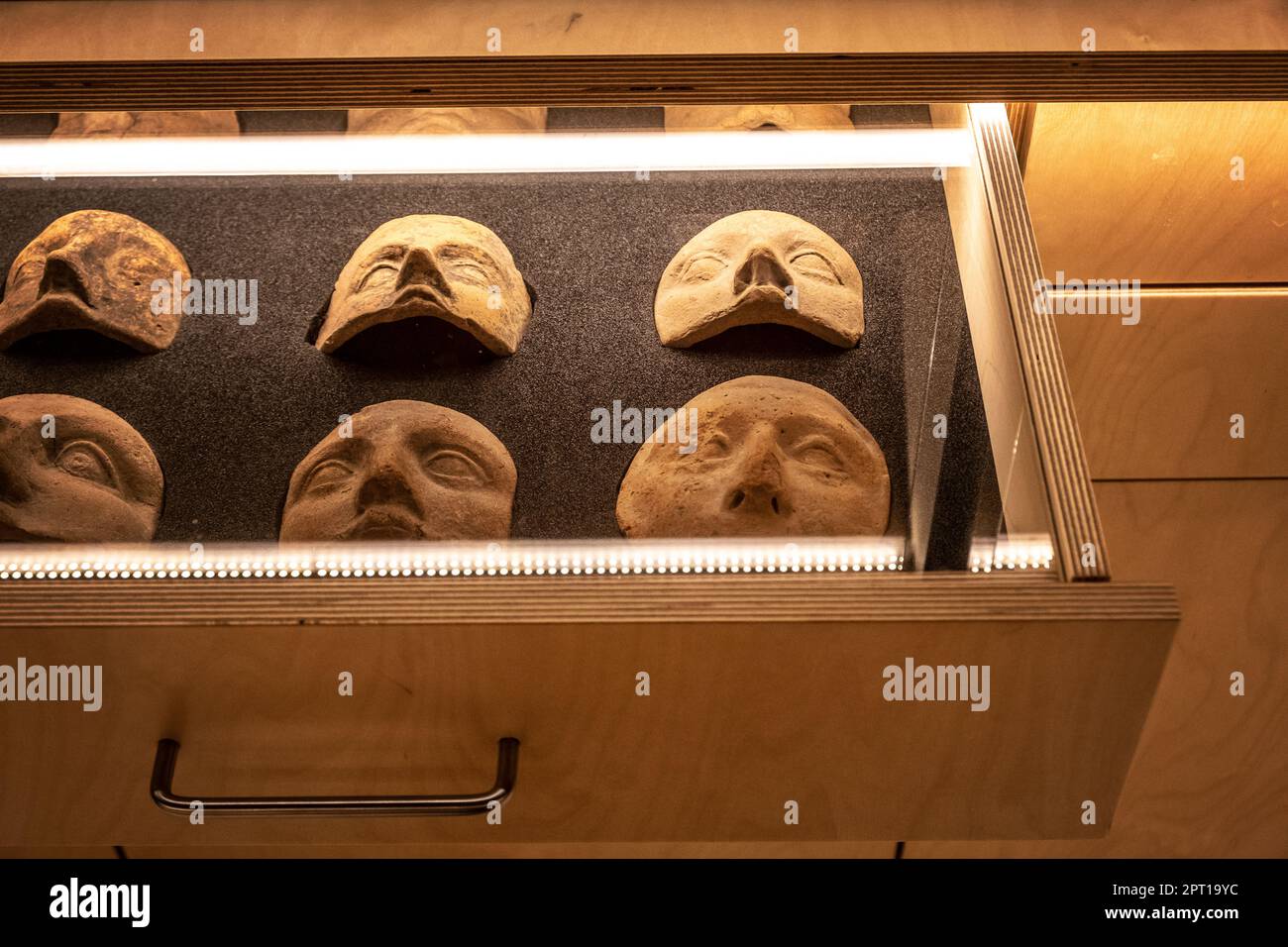 Málaga, Espagne -- masques anciens en argile exposés dans un coffret en verre au Museo de Málaga Banque D'Images
