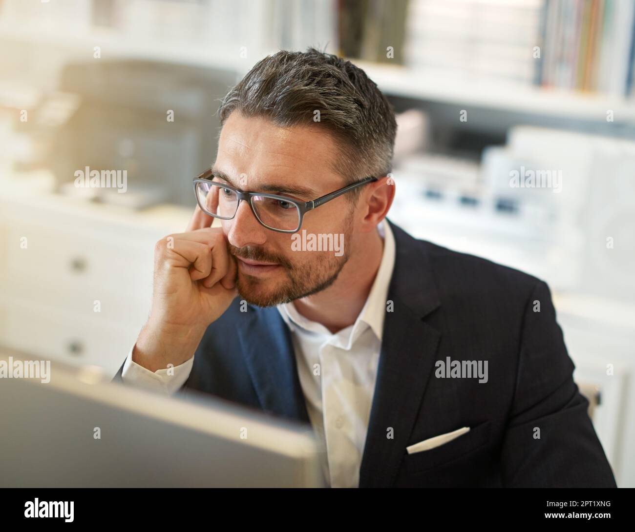 HES le solutionneur de problème que vous voulez de votre côté. un homme d'affaires travaillant sur son ordinateur dans un bureau Banque D'Images