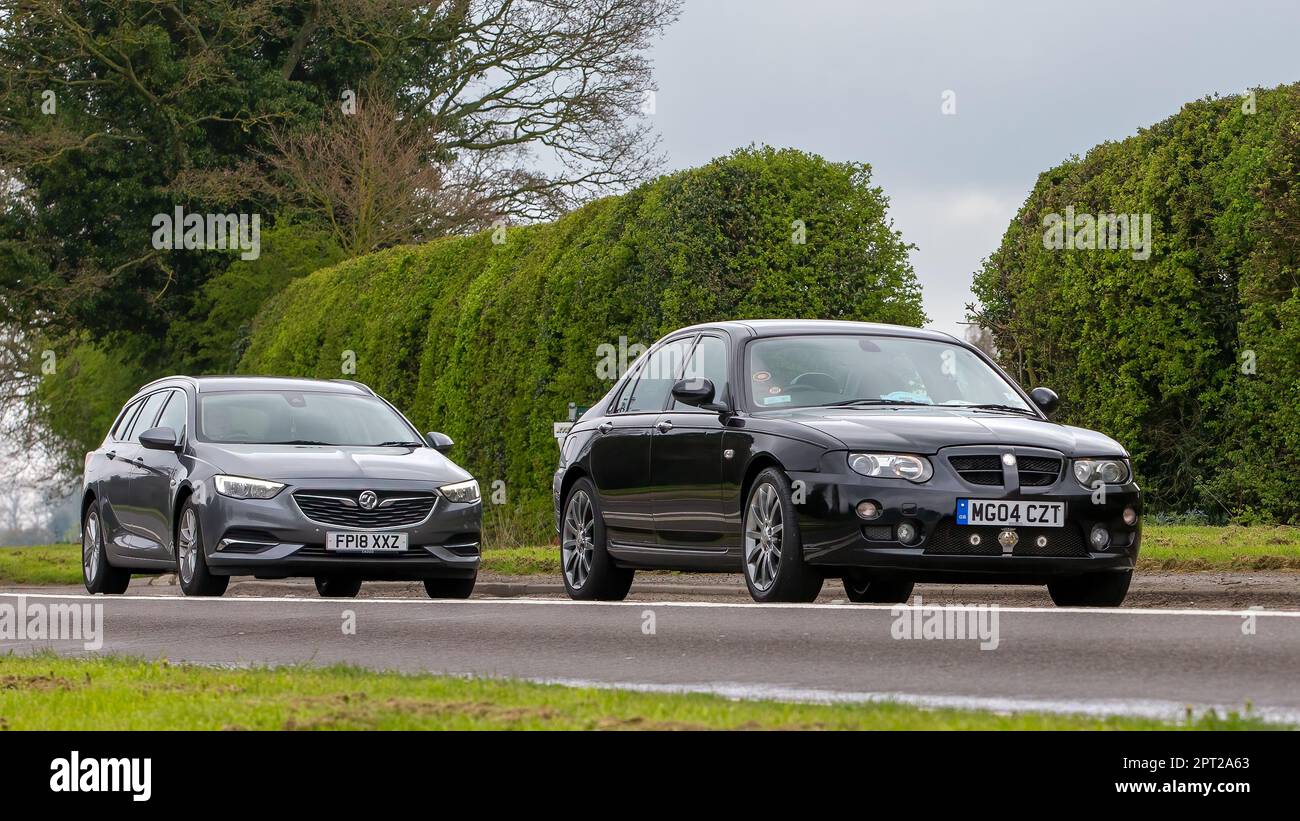 Bicester,Oxon,UK - 23 avril 2023.deux voitures, VAUXHALL INSIGNE et MG ZT voyageant sur une route de campagne anglaise Banque D'Images