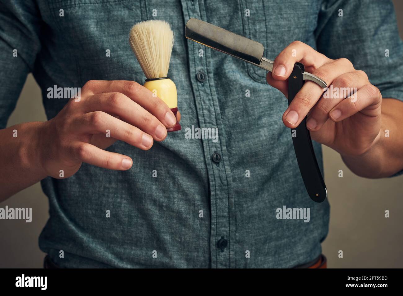 Prenez le temps de vous amuser. un beau jeune homme tenant un rasoir droit  et une brosse à rasoir dans les mains Photo Stock - Alamy