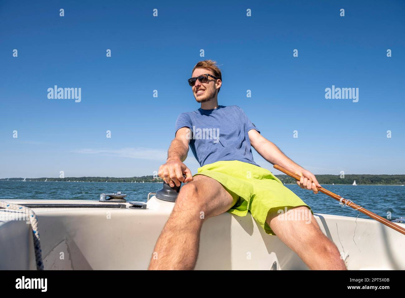 Jeune homme naviguant sur un voilier, lac Ammer, Bavière, Allemagne Banque D'Images