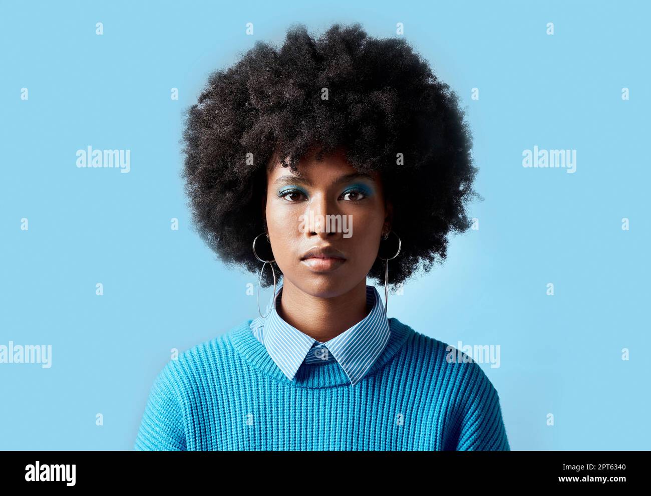 Femme noire afro, portrait et visage sérieux pour la vision dans le focus sur un fond bleu de studio. Modèle féminin africain de mode cool avec e cosmétique Banque D'Images