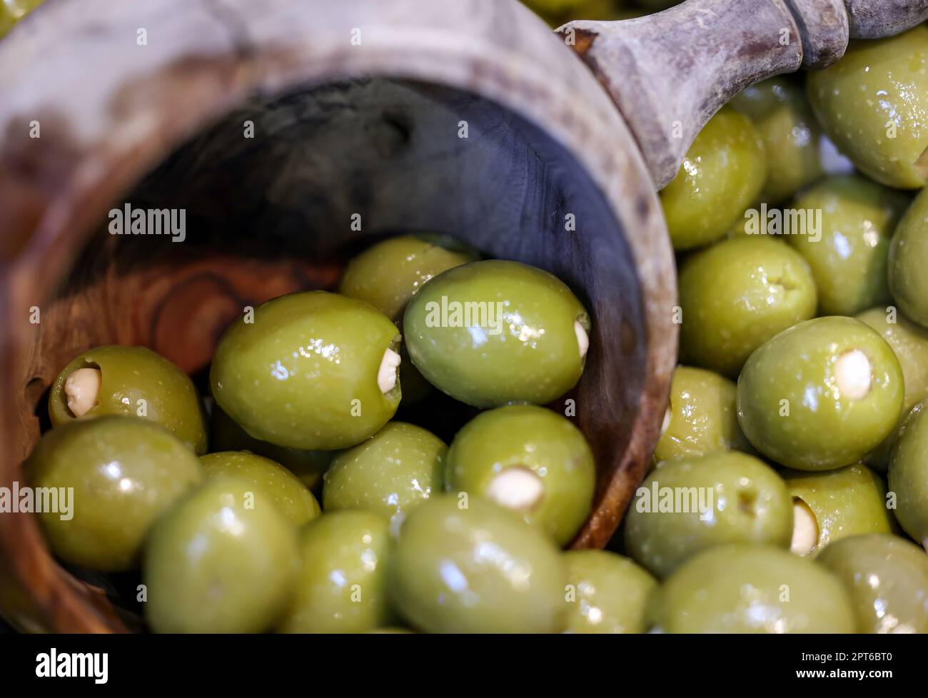 Olives vertes farcies dans un ancien bol en bois Banque D'Images