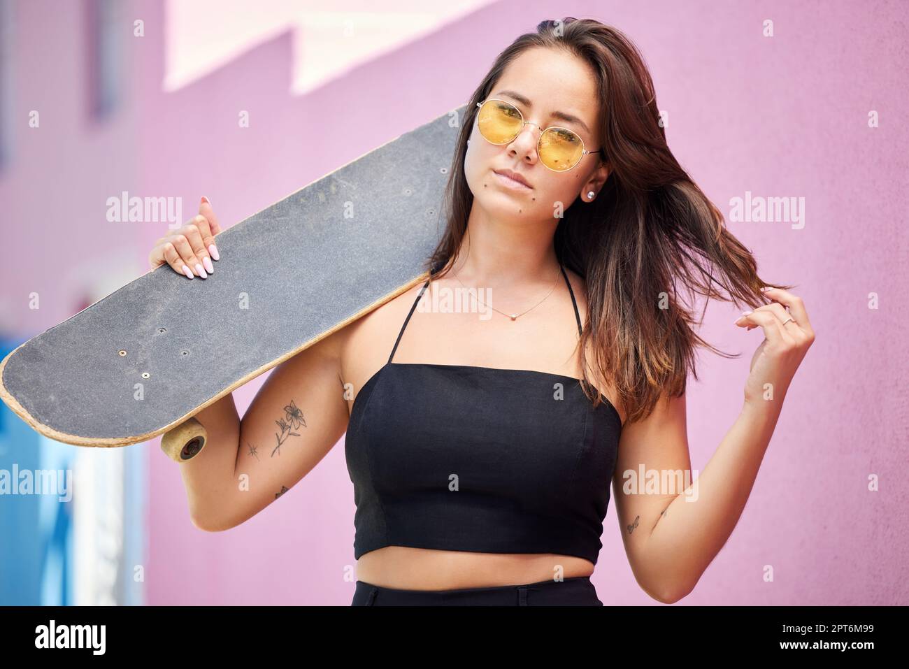 Portrait de femme, lunettes de soleil et skateboard look rétro dans la ville urbaine sur la rue style aventure. Jeune asiatique tendance patineuse fille, gen z ou millénaire l Banque D'Images