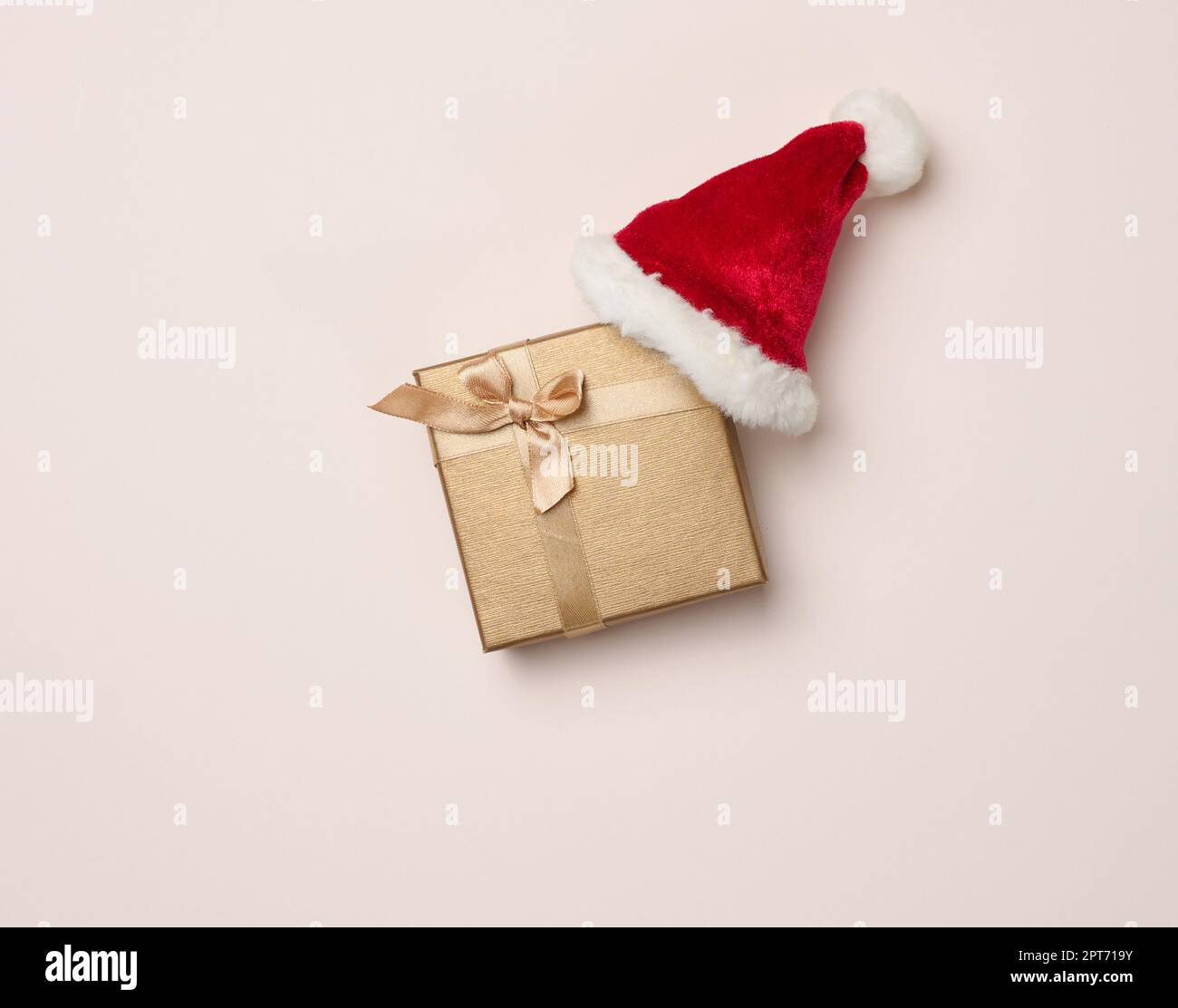 Boîte carrée et chapeau de père noël rouge sur fond beige. Décoration de  Noël, vue sur le dessus Photo Stock - Alamy