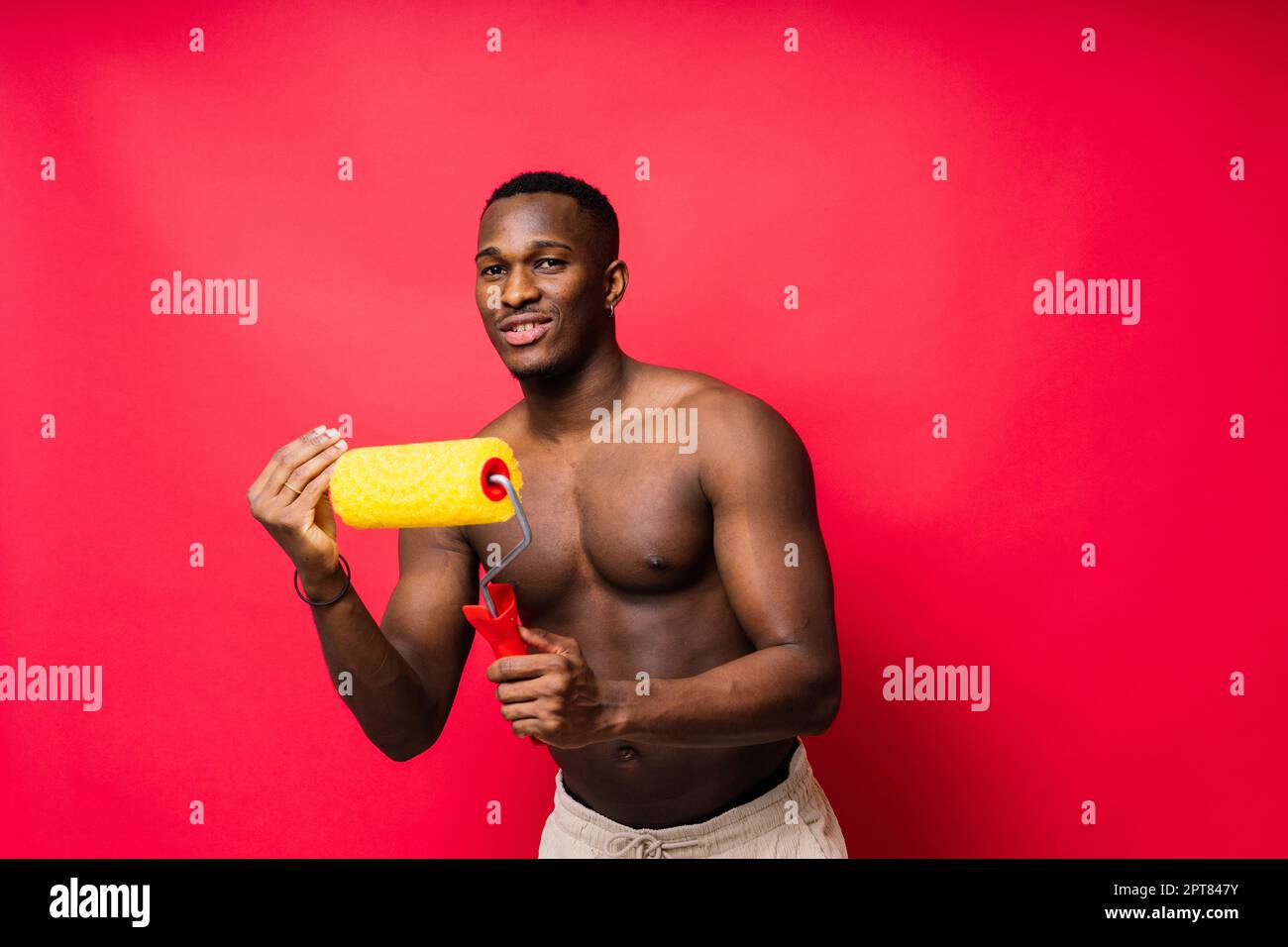 Peintre afro-américain sur fond de studio rouge, sans à-coup Banque D'Images
