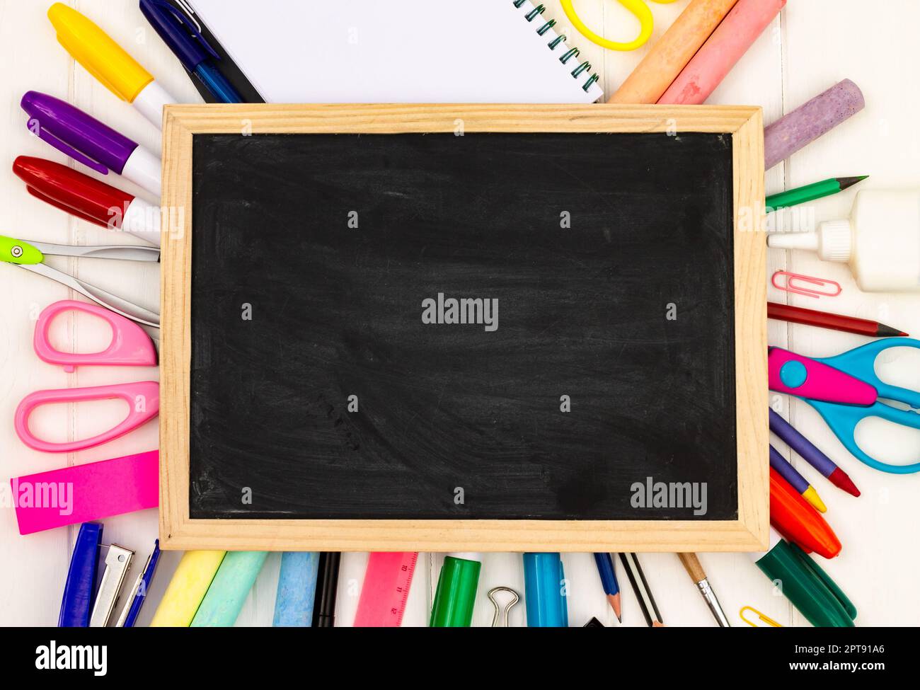 Retour à l'école tableau noir de craie sur fond blanc en bois, fournitures de couleur. Vue de dessus. Copier l'espace. Concept d'éducation Banque D'Images