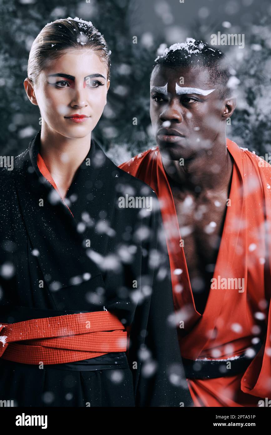 Mystique culturelle. Photo de mode d'un homme et d'une femme portant des vêtements de style oriental dans la neige qui tombe Banque D'Images