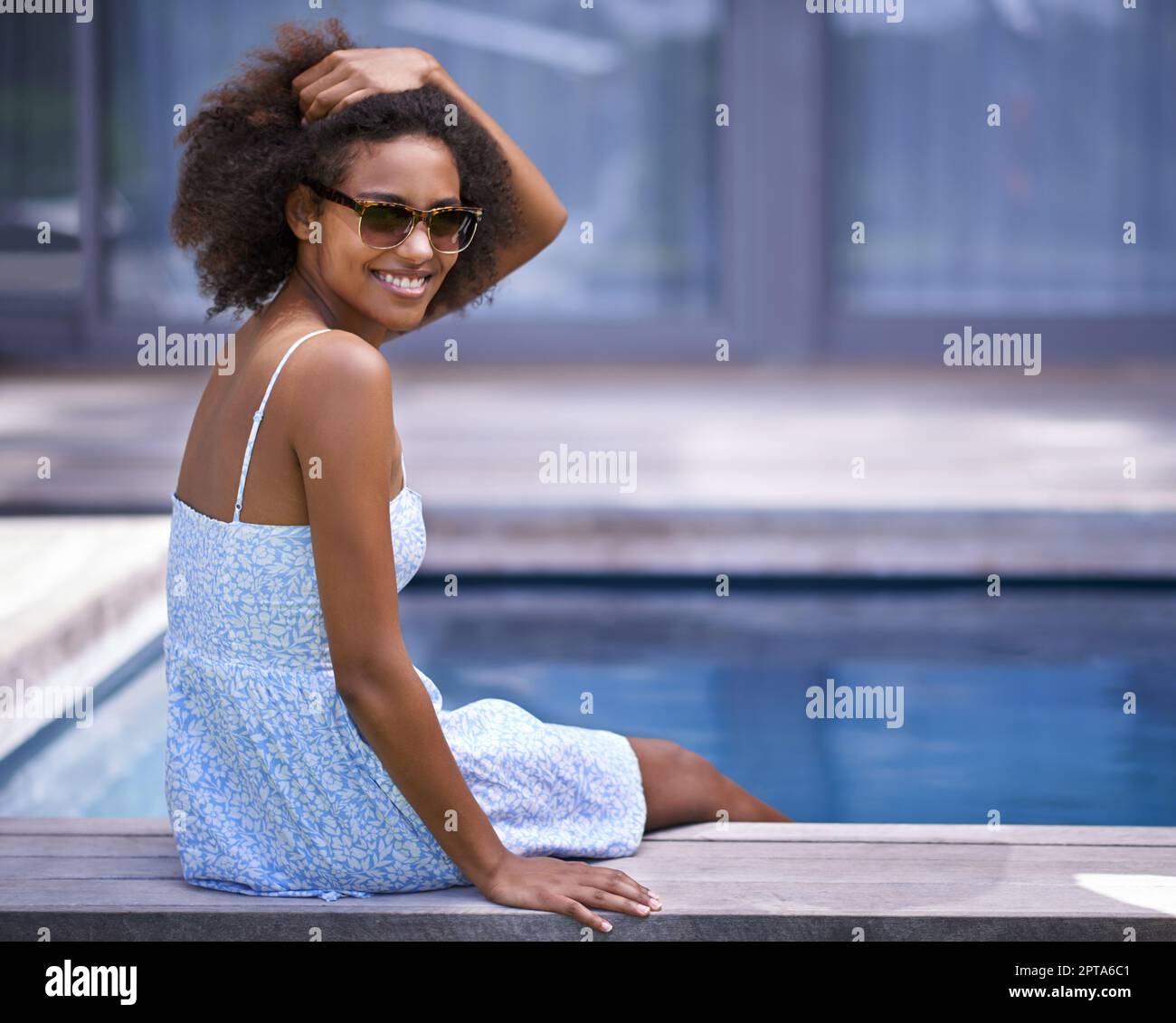 Je n'aurais pas envie d'être là, mais ici. Photo complète d'une jolie femme ethnique qui se pose au bord de la piscine Banque D'Images