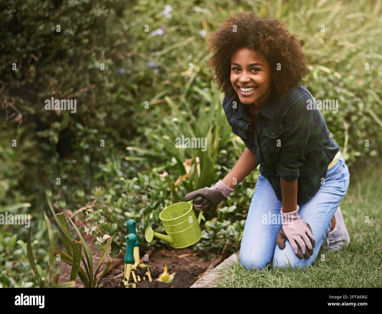 Maintenant, attendre et voir comment ils grandissent. Une jeune femme arroser des plantes dans son jardin Banque D'Images