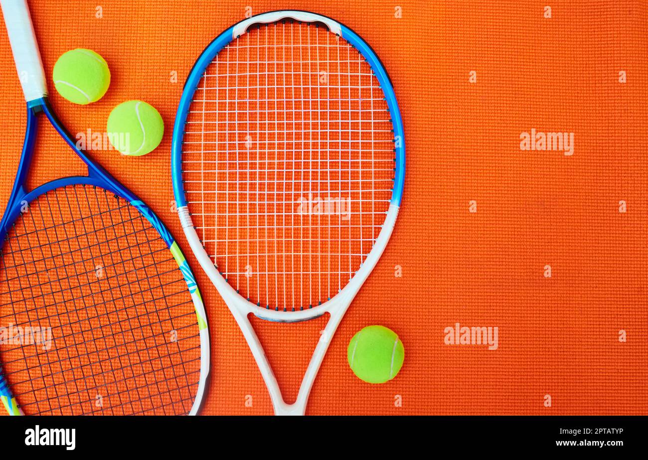 Vous avez atteint votre niveau. Prise de vue en grand angle des articles de tennis placés sur un fond orange à l'intérieur d'un studio Banque D'Images