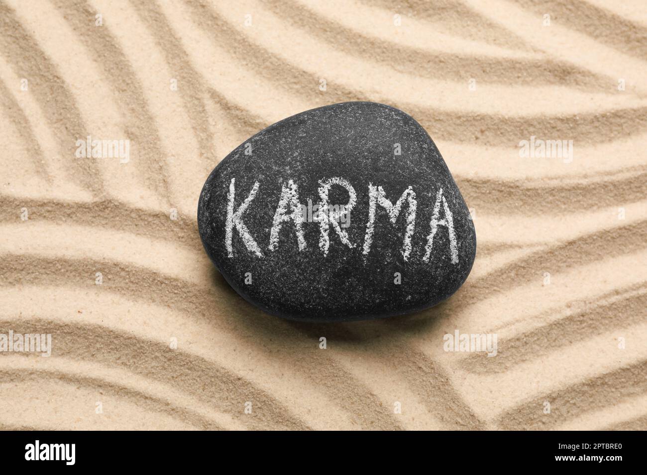 Pierre avec le mot Karma sur le sable, vue de dessus Banque D'Images
