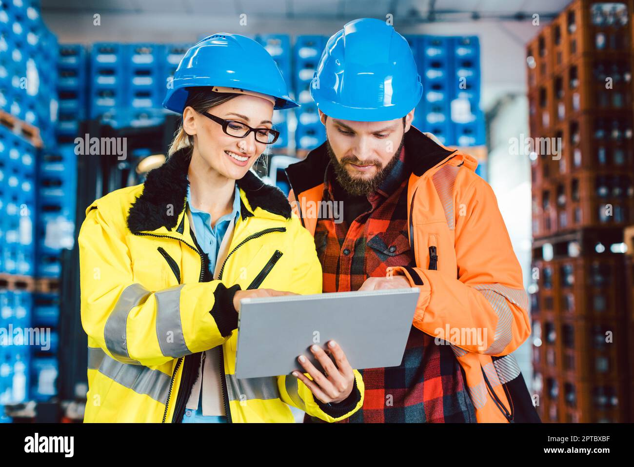 Femme et homme en tant que travailleurs dans le centre logistique utilisant des données de vérification d'ordinateur Banque D'Images