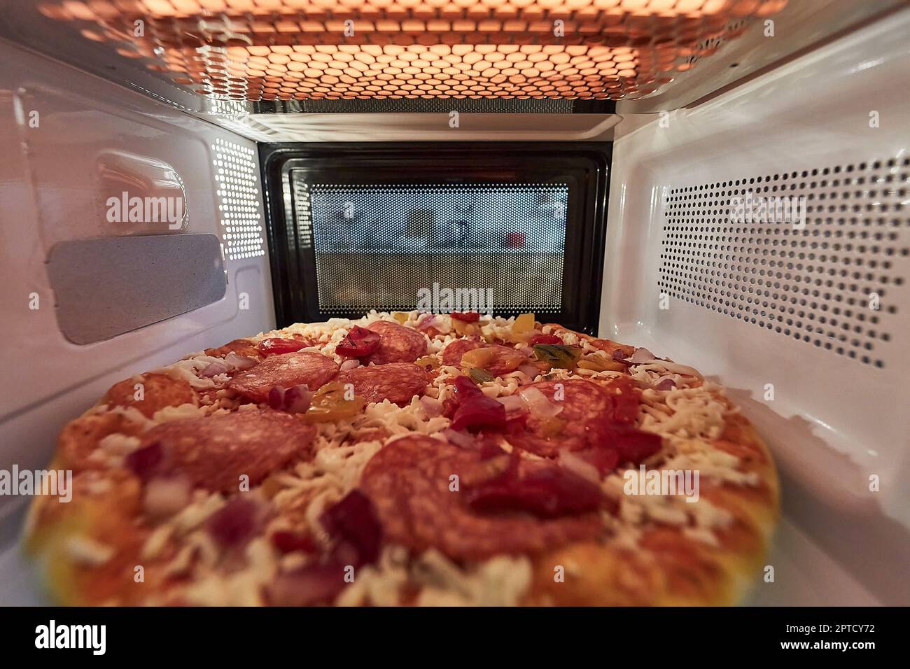 Chauffer de la pizza surgelée dans un micro-ondes vu de l'intérieur de  l'arrière Photo Stock - Alamy