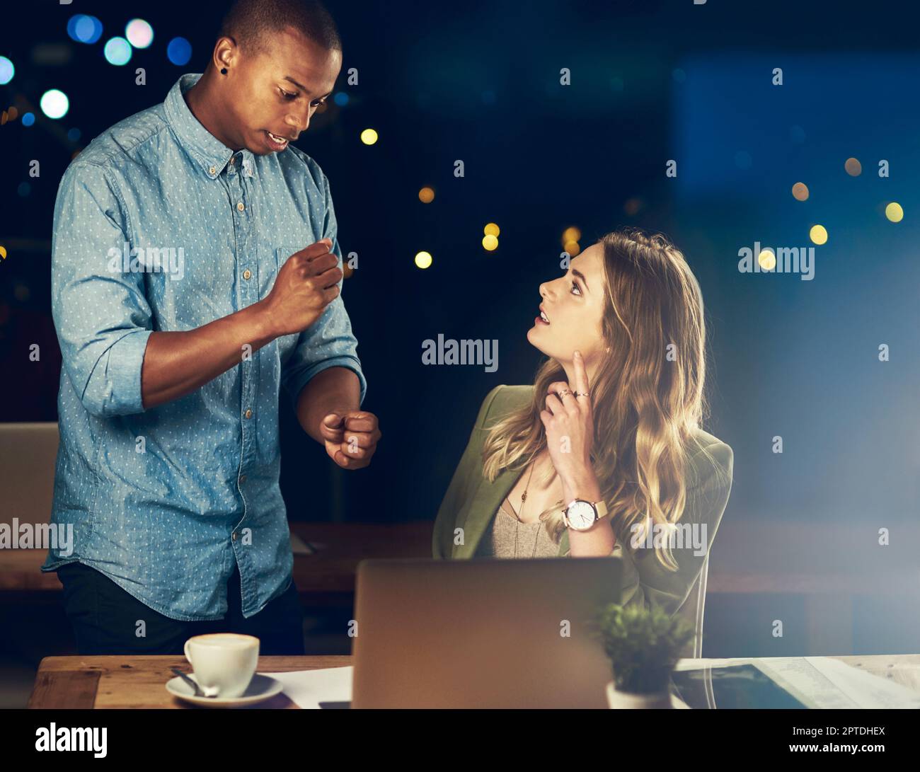 Juste une petite chose... deux jeunes collègues travaillant tard au bureau ensemble Banque D'Images