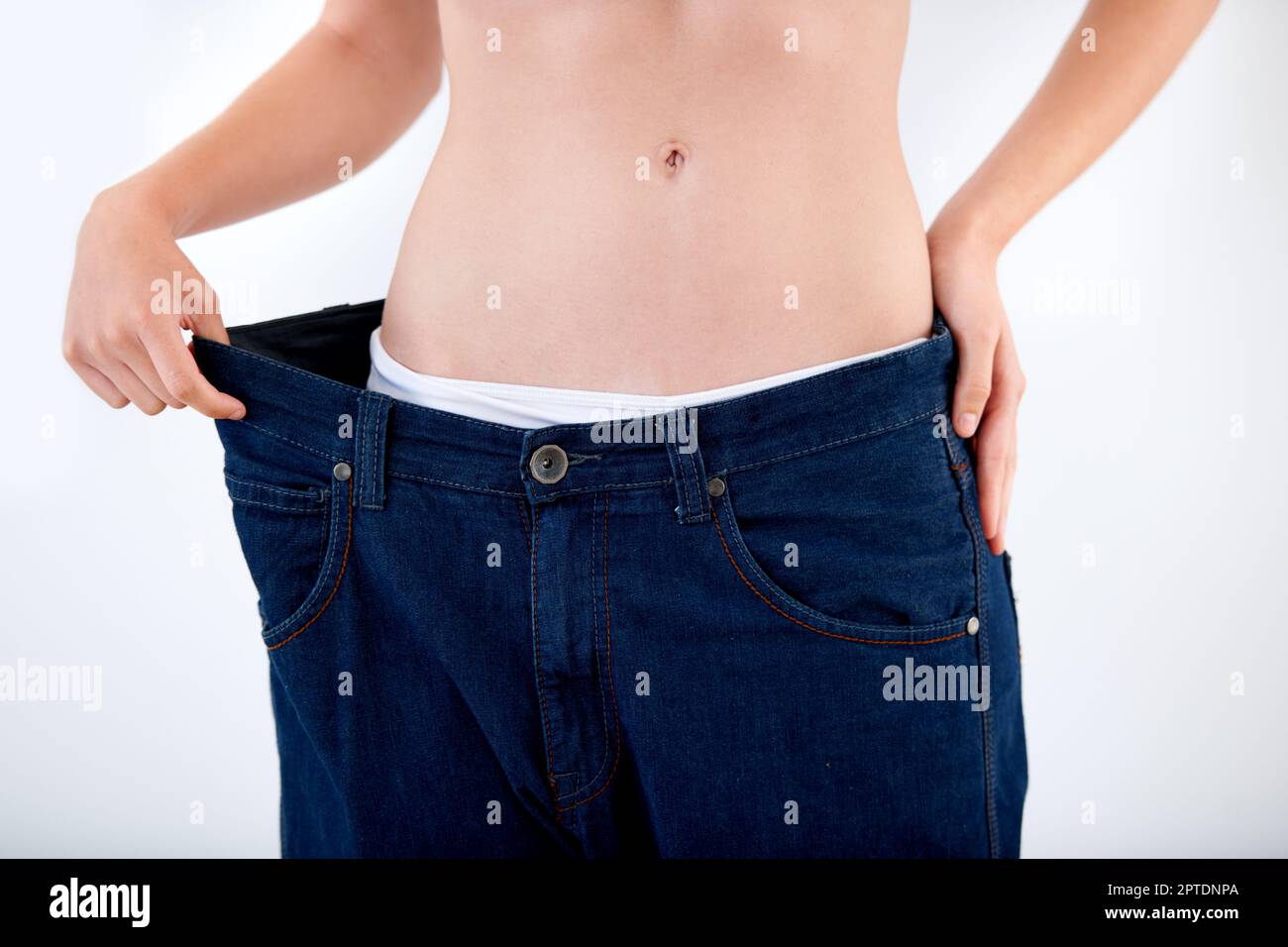 Atteindre ses objectifs de perte de poids. Image rognée d'une femme tirant  la ceinture de son pantalon - perte de poids Photo Stock - Alamy