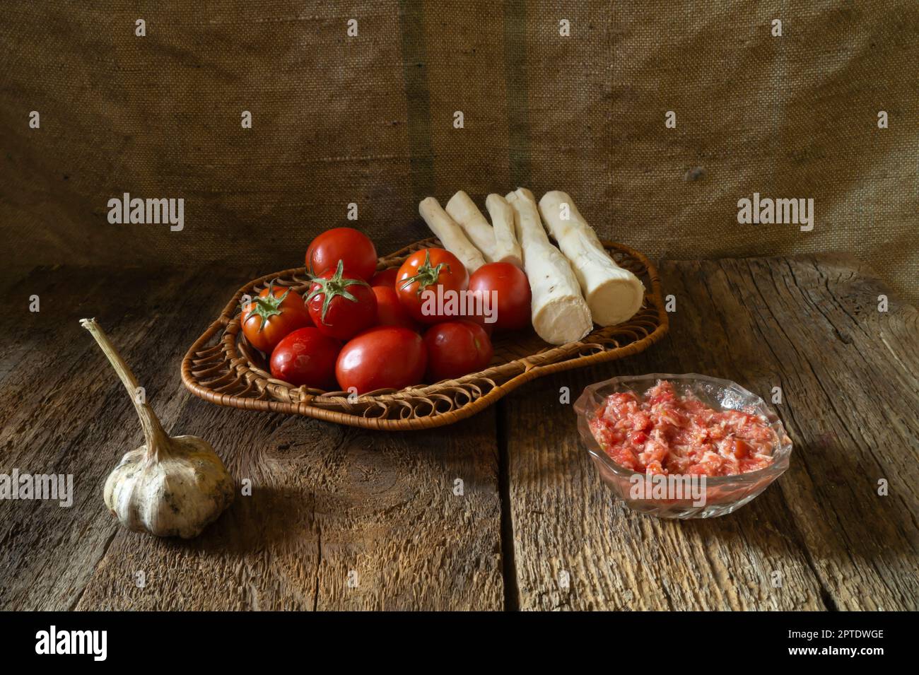 Tomates et racine de raifort pour faire un assaisonnement épicé. Légumes mûrs sur fond sombre Banque D'Images