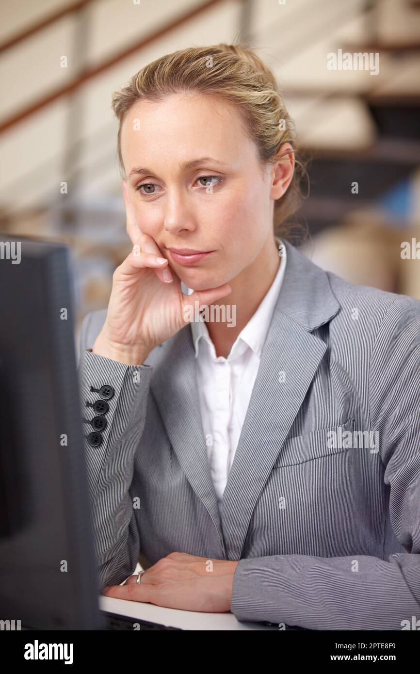 Ennui d'affaires. Une femme d'affaires assise sur son ordinateur avec l'expression de l'ennui sur son visage Banque D'Images