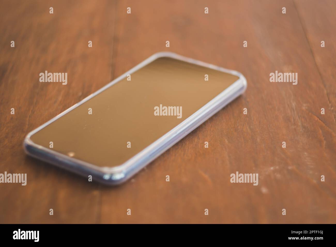 Smartphones noirs placés sur une table en bois marron Banque D'Images