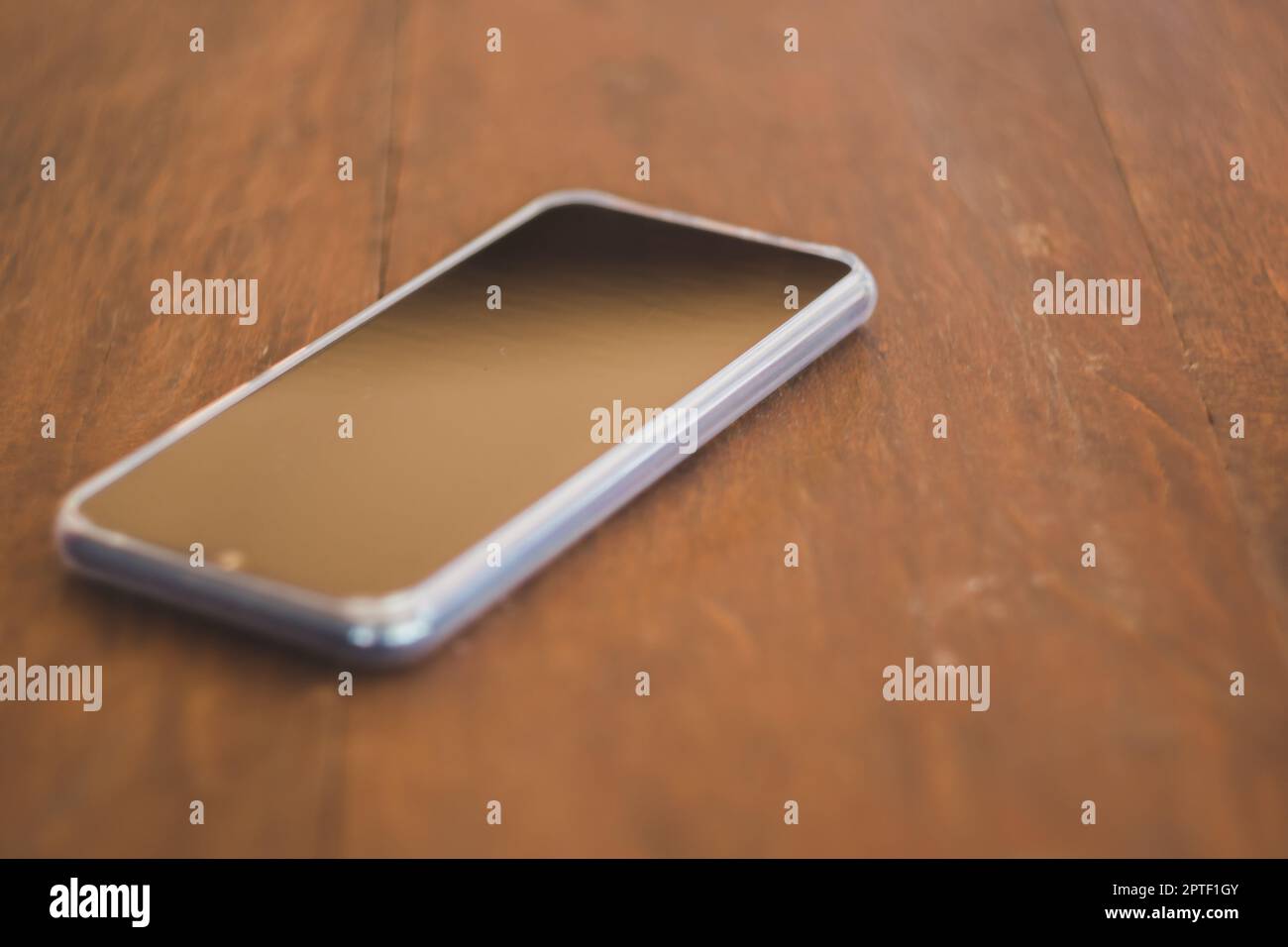 Smartphones noirs placés sur une table en bois marron Banque D'Images