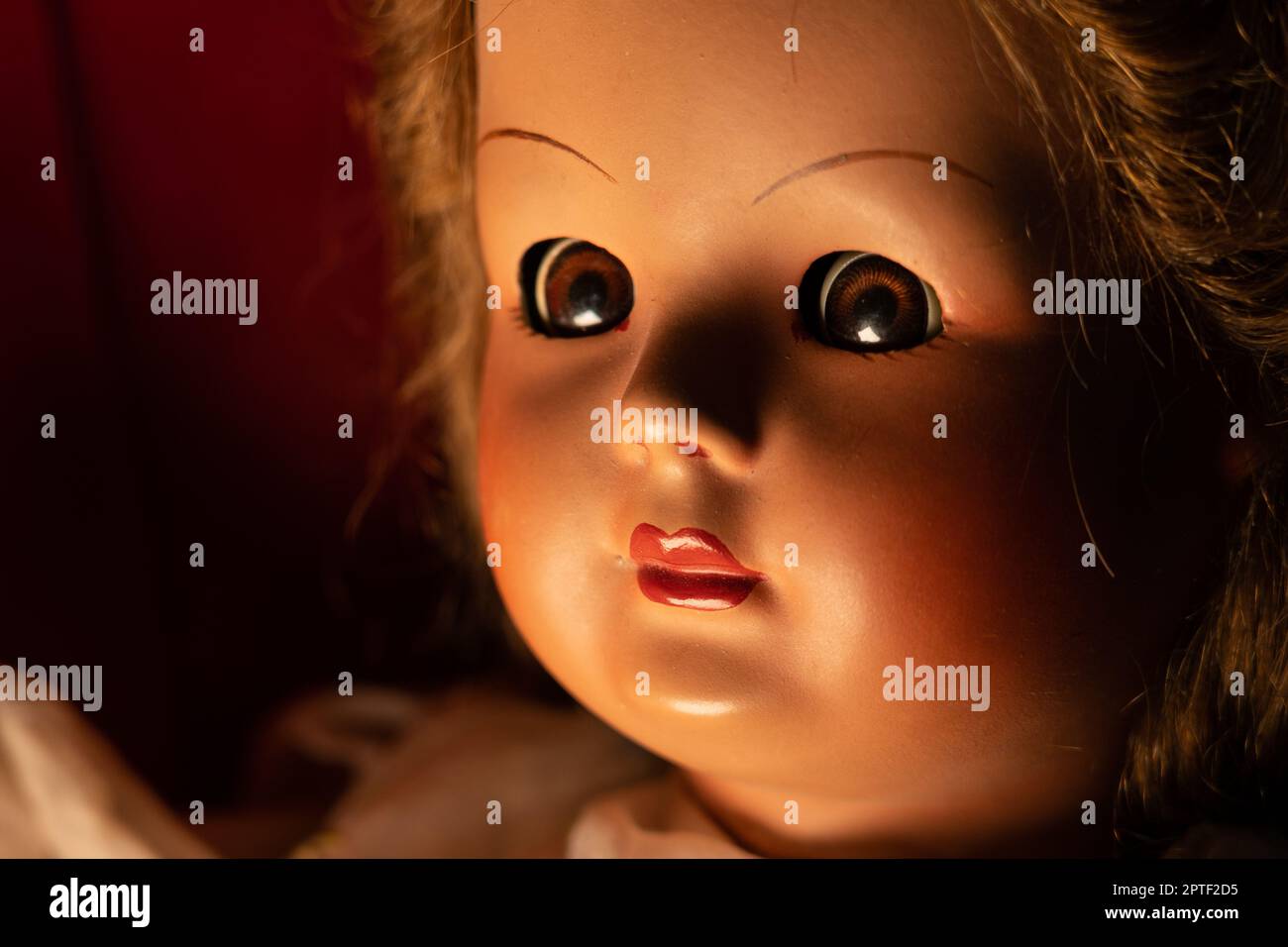 Poupée vintage effrayante en demi-lumière. Gros plan Banque D'Images