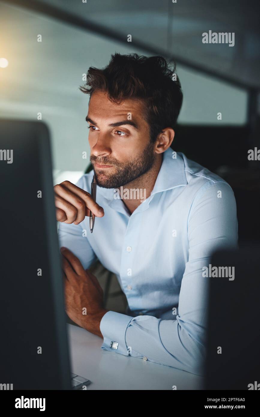 Vous devez essayer de voir les résultats. un jeune homme d'affaires travaillant tard sur un ordinateur dans un bureau Banque D'Images