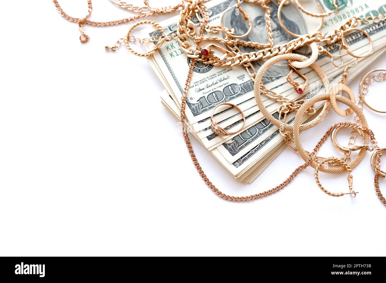 Beaucoup de bagues, boucles d'oreilles et colliers de bijoux d'or chers avec beaucoup de billets de dollars américains sur fond blanc. Concept de la boutique de prêt-à-acheter ou de la bijouterie Banque D'Images