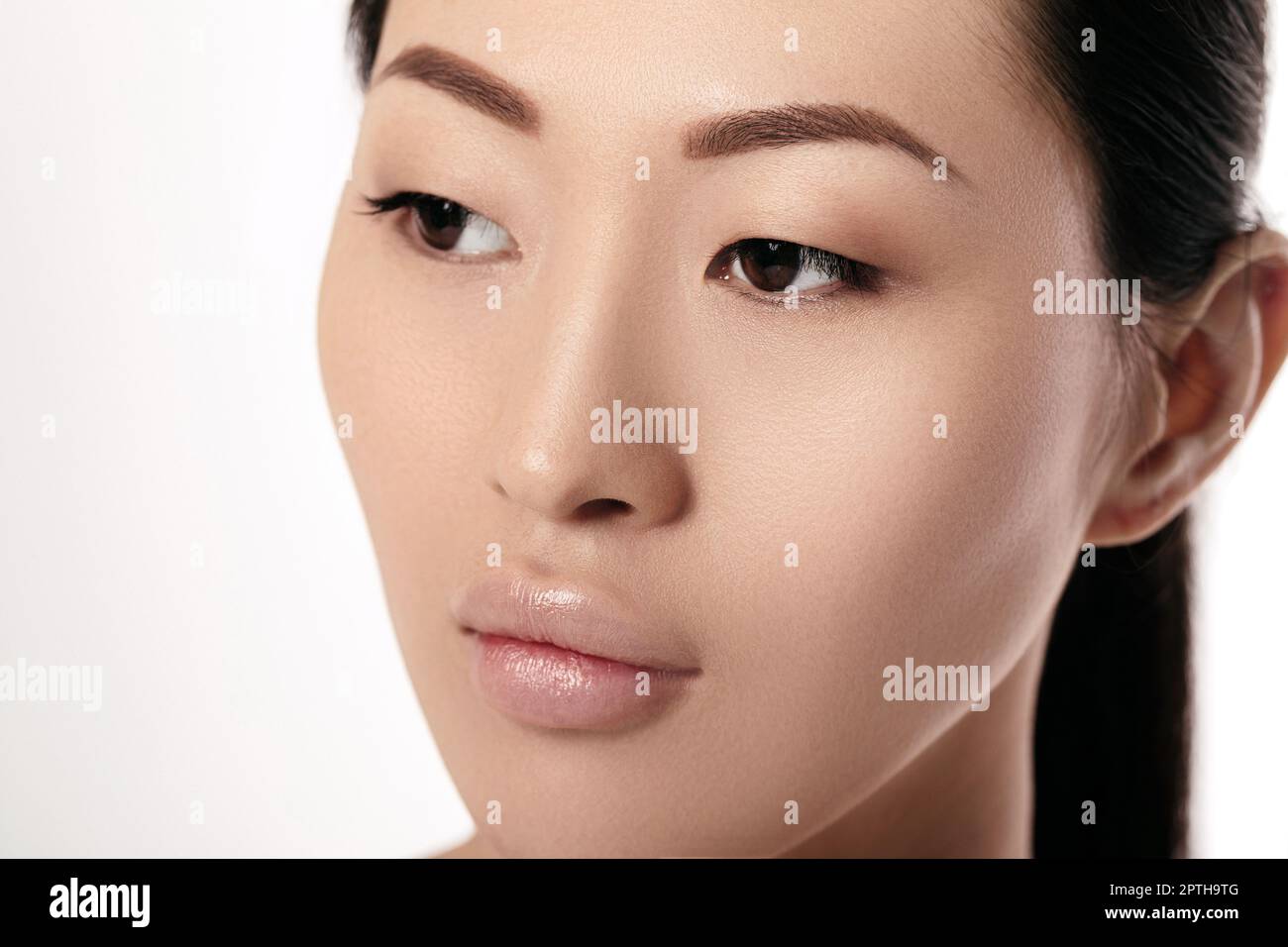 Close-up portrait of beautiful young asian woman on white background libre. fille avec la peau propre. Procédé d'augmentation après lèvres femelle Banque D'Images