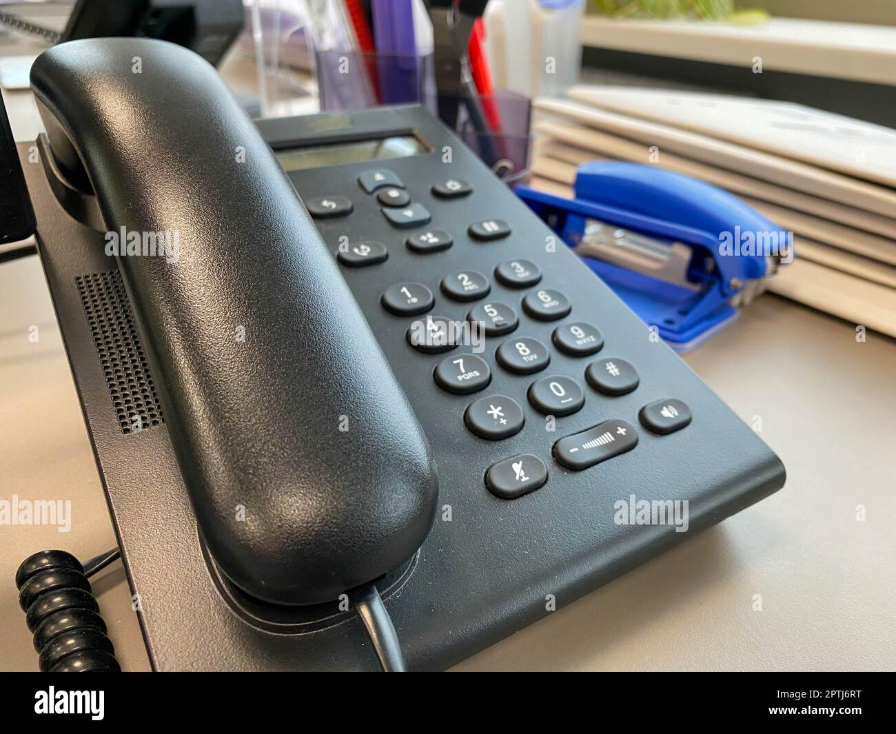 Téléphone filaire de bureau en plastique noir avec combiné et boutons pour résoudre les problèmes de l'entreprise et passer des appels à la négociation. Banque D'Images