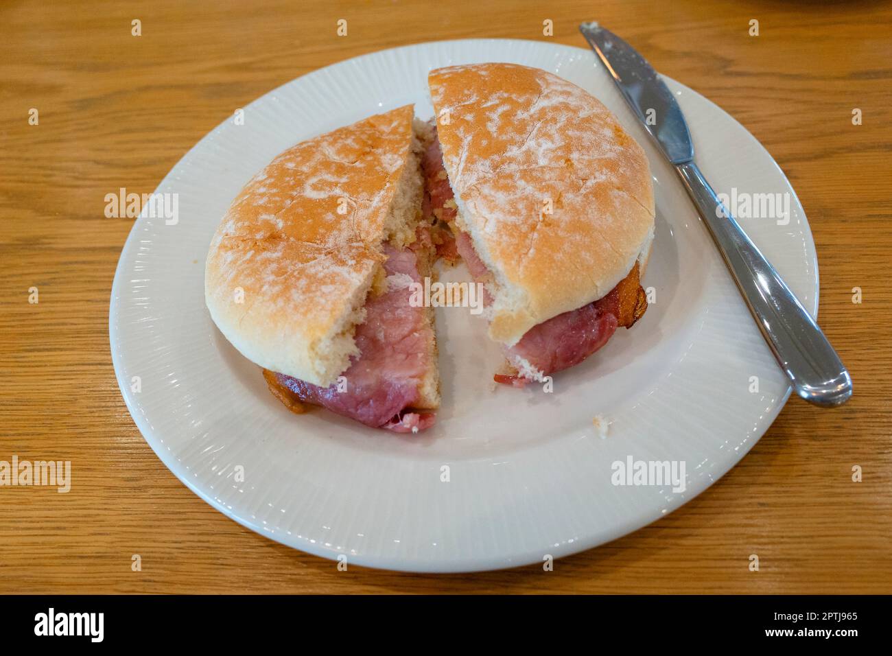 Yorkshire snack un bacon avec un couteau sur une table en bois Banque D'Images