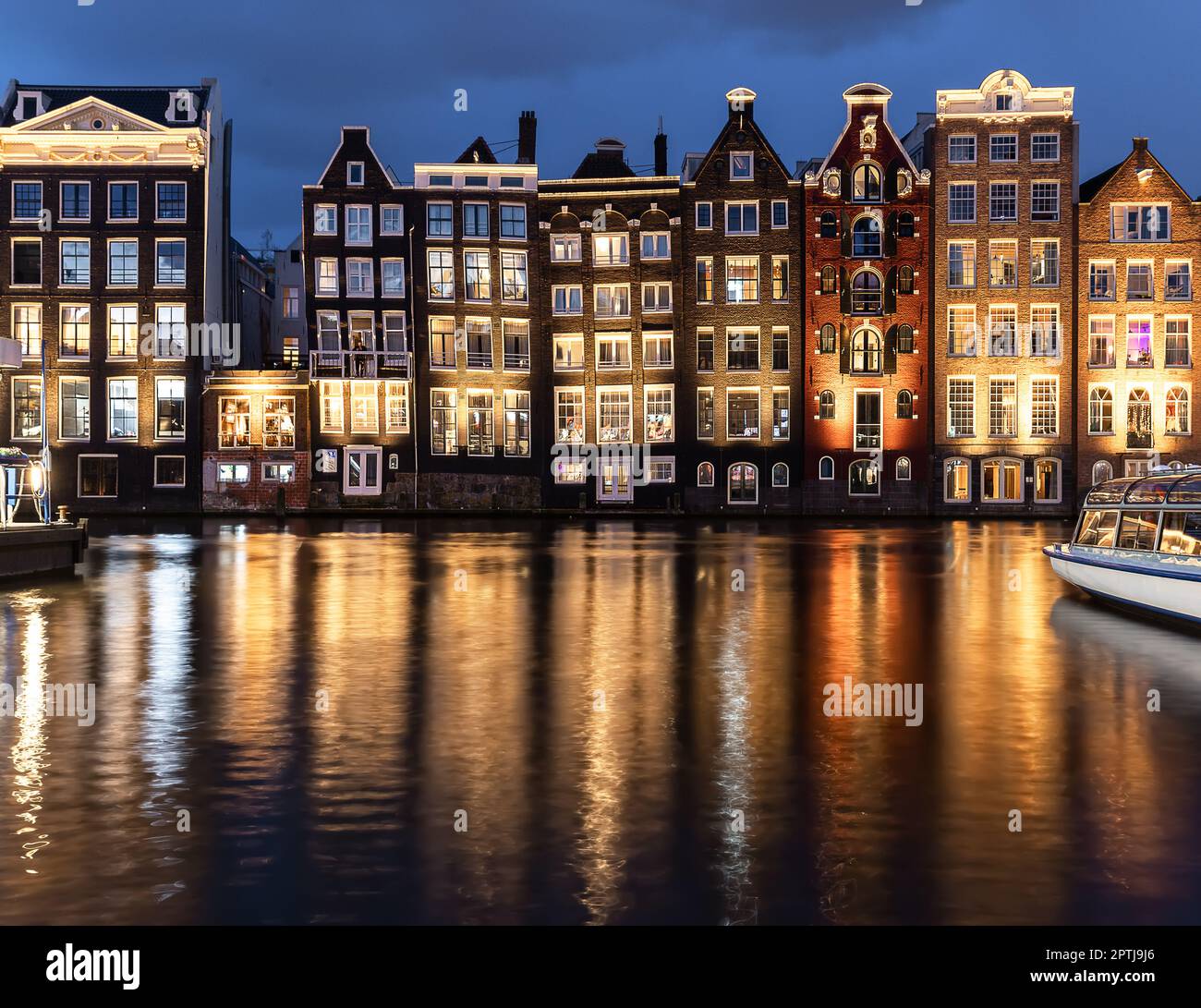 Maisons dansantes Damrak Amsterdam pendant la soirée lumières pays-Bas Hollande. Superbes maisons minces et tordues qui sont devenues des monuments d'Amsterdam, Banque D'Images