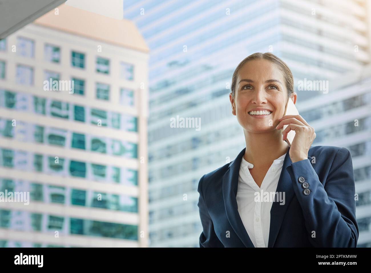 Se tenir au courant des clients. une jeune femme d'affaires parle sur son téléphone portable sur le chemin du bureau. Banque D'Images