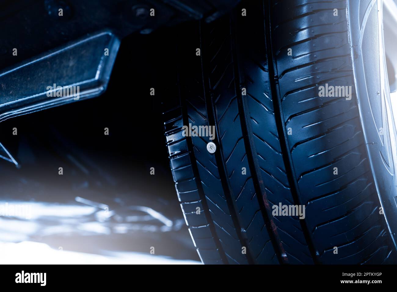 Vis ou clou pneu en caoutchouc noir perforé pour voiture. Accident de roue  de voiture sur route avec pneu crevé. Conduire avec un clou dans le pneu.  Retirez et réparez l'ongle métallique