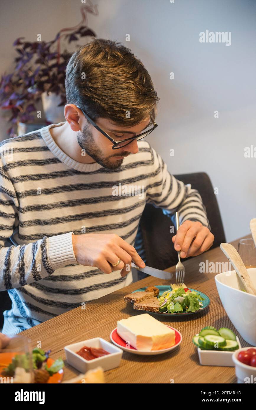 Homme mangeant un repas froid avec salade, Munich, Allemagne Banque D'Images