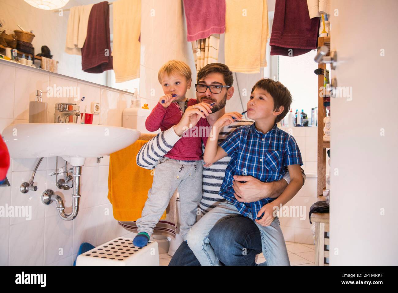 Père et ses fils se brossant les dents dans la salle de bains, Munich, Allemagne Banque D'Images