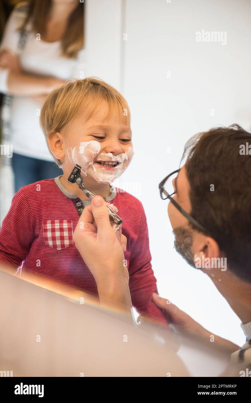 Père rasant son petit fils pour blague, Munich, Allemagne Banque D'Images