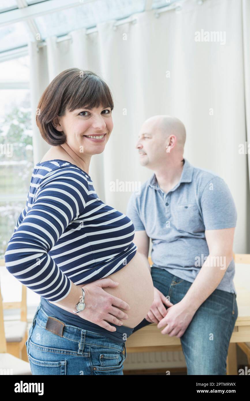 Portrait d'une femme enceinte avec son mari assis sur une table Banque D'Images