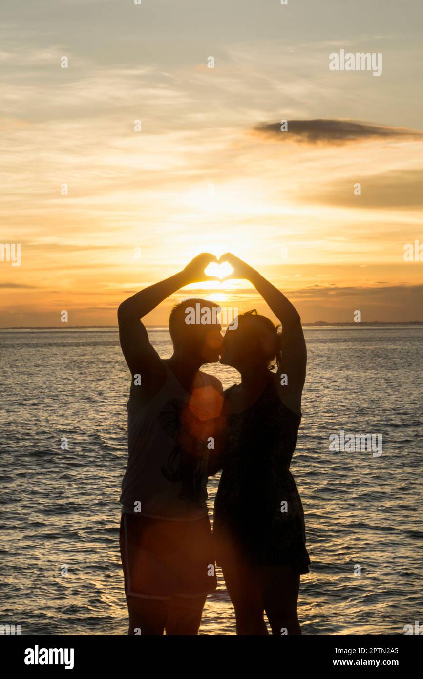 Silhouette de couple en forme de coeur avec les mains, Nusa lembongang, Bali, Indonésie Banque D'Images