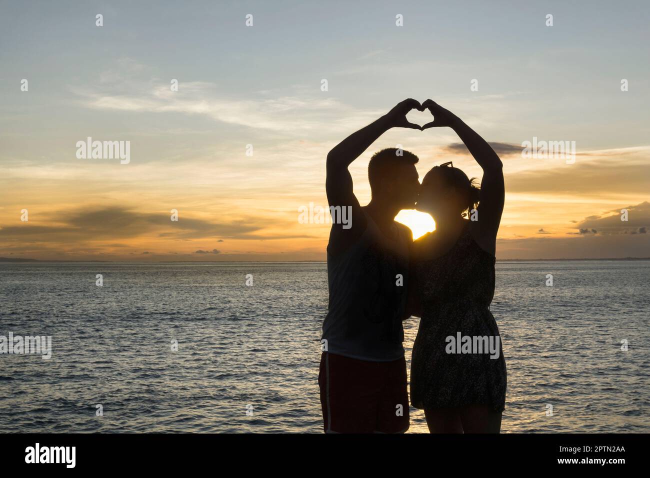 Silhouette de couple en forme de coeur avec les mains, Nusa lembongang, Bali, Indonésie Banque D'Images