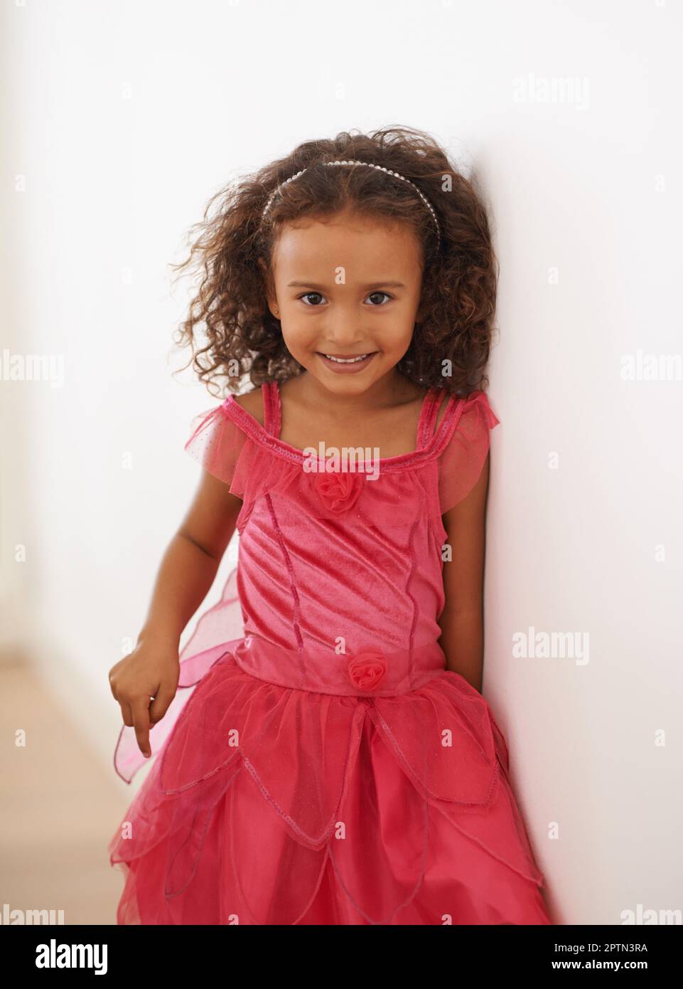 Je suis une princesse de fées. Portrait d'une petite fille dans une robe rose souriant à l'appareil photo Banque D'Images