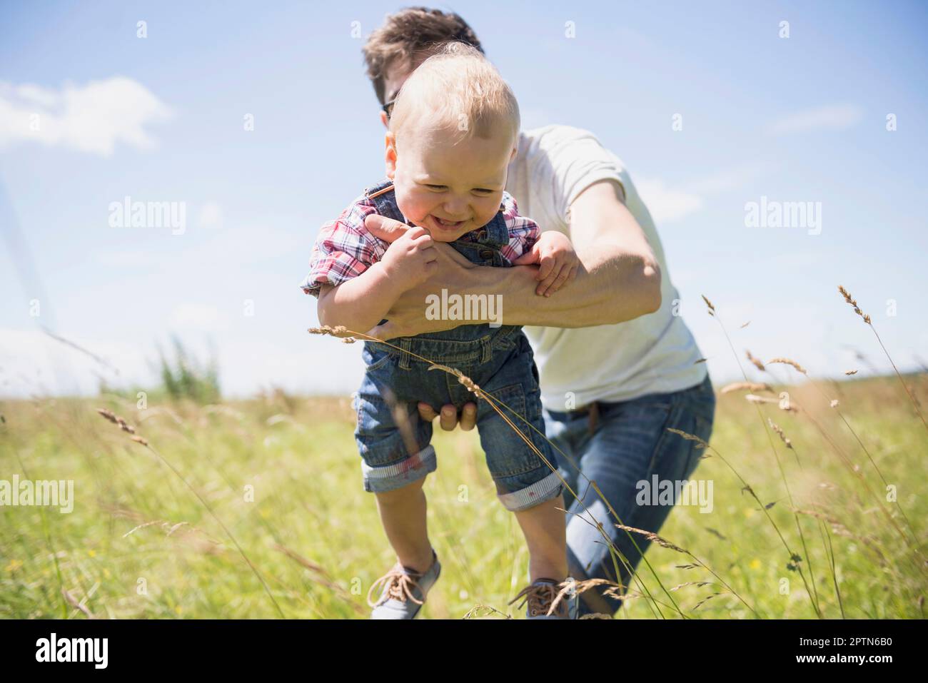 Heureux homme jouant avec son fils dans la campagne, Bavière, Allemagne Banque D'Images